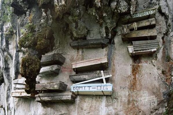 Сагада – небольшая филиппинская деревушка, получившая известность благодаря особому способу организации похорон. Он считается достаточно древним (согласно некоторым источникам ему более двух тысяч лет), при этом нигде больше на Филиппинах не практикуется. Хоронили в деревянных гробах, однако заготовку погребального контейнера усопший делал еще при жизни. Причем его не сбивали из досок, а выскабливали в цельном стволе дерева. За право взять на плечи умершего иногда приходилось бороться: по поверьям, после смерти удача и таланты какое-то время еще остаются в теле покойного и могут передаться тем, кто его несет.Тело приносили  к поросшим соснами скалам. К моменту похорон короб уже был закреплен на отвесных скалах, и оставалось уложить в него умершего.Коренной народ Сагады верит, что воздушные похороны приближают усопшего к богу. В древности к захоронению на скале допускались только старики, успевшие обзавестись семьей и внуками. Сегодня чести получить место на кладбище в скалах удостаиваются только старейшины общины.На фото: висячие гробы в Сагаде, Филиппины.